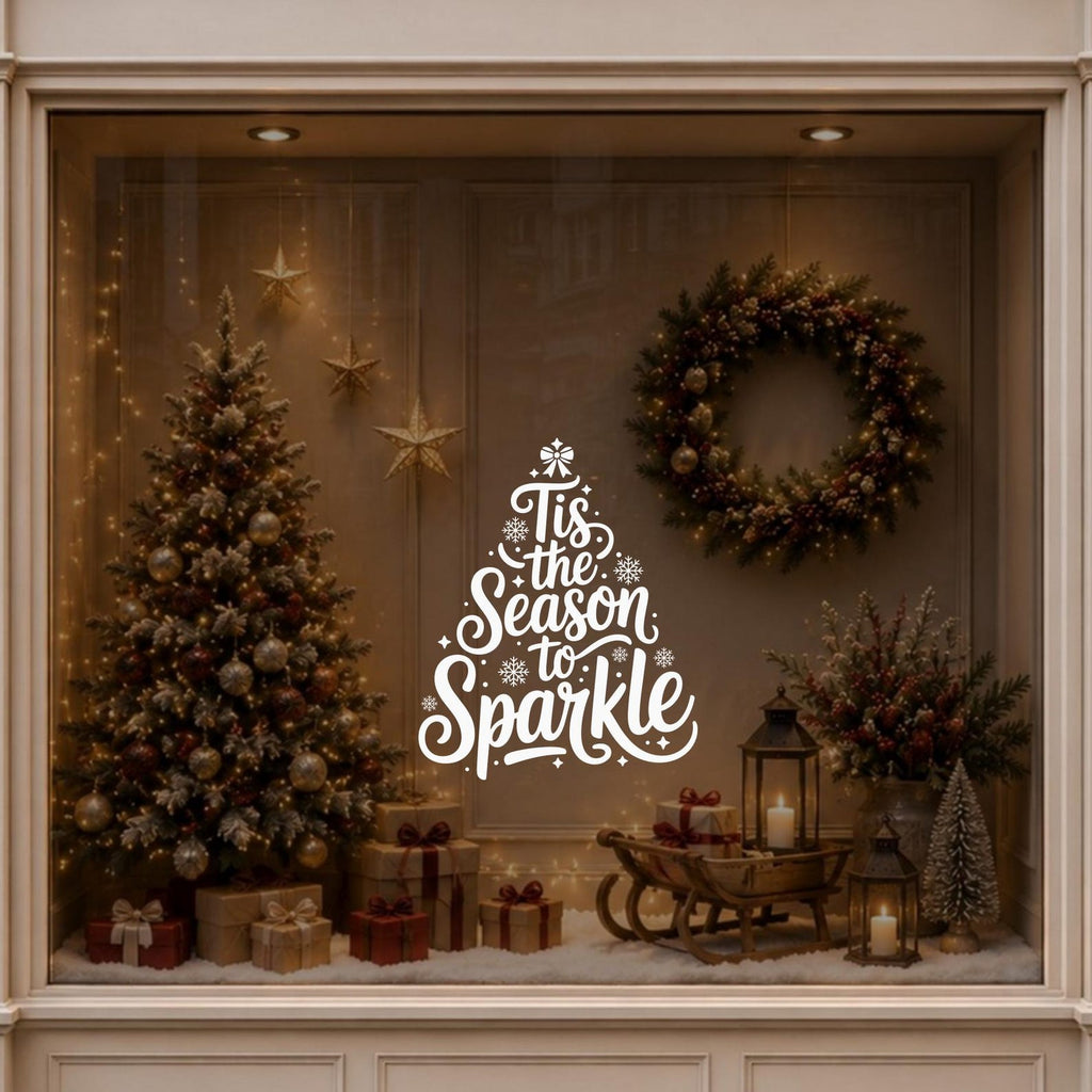 Christmas tree lettering window sticker displayed on a warmly decorated festive shop window.