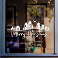 White Merry Christmas village window sticker with houses, trees, stars and crescent moon displayed on a shop window
