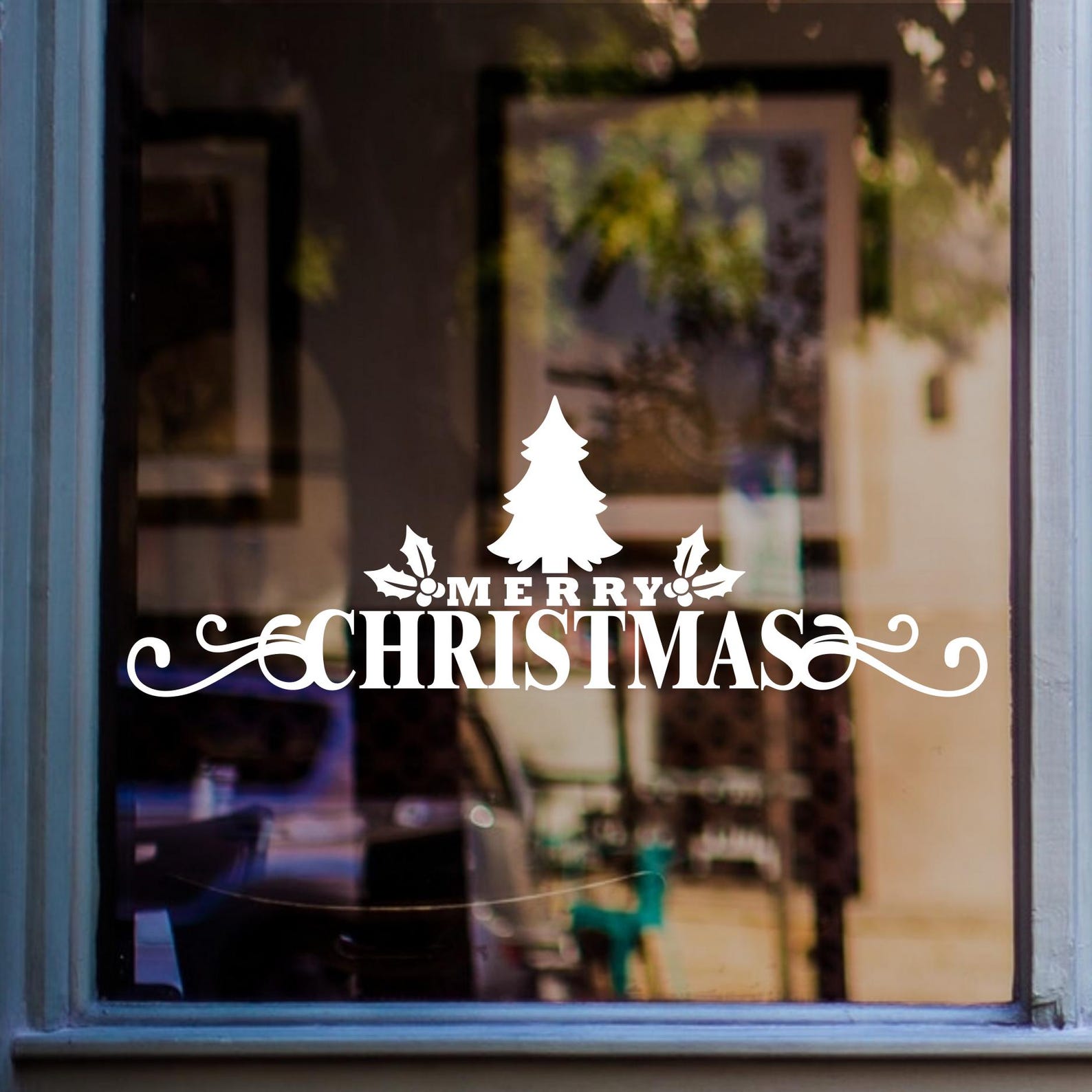 Merry Christmas window sticker with Christmas tree and decorative flourishes displayed on glass.