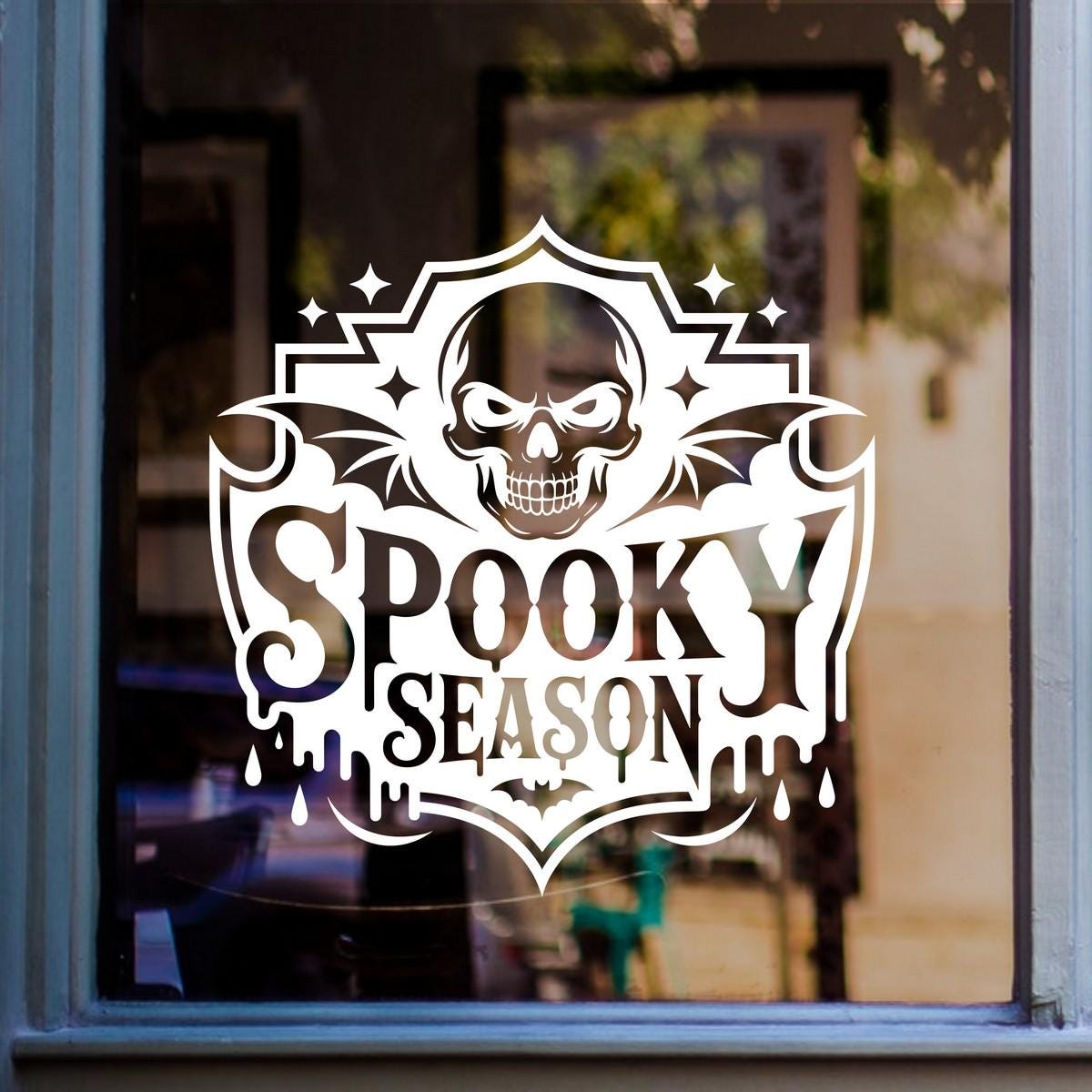 Spooky Season Skull Halloween Window Sticker: white vinyl design on a blue-framed glass door