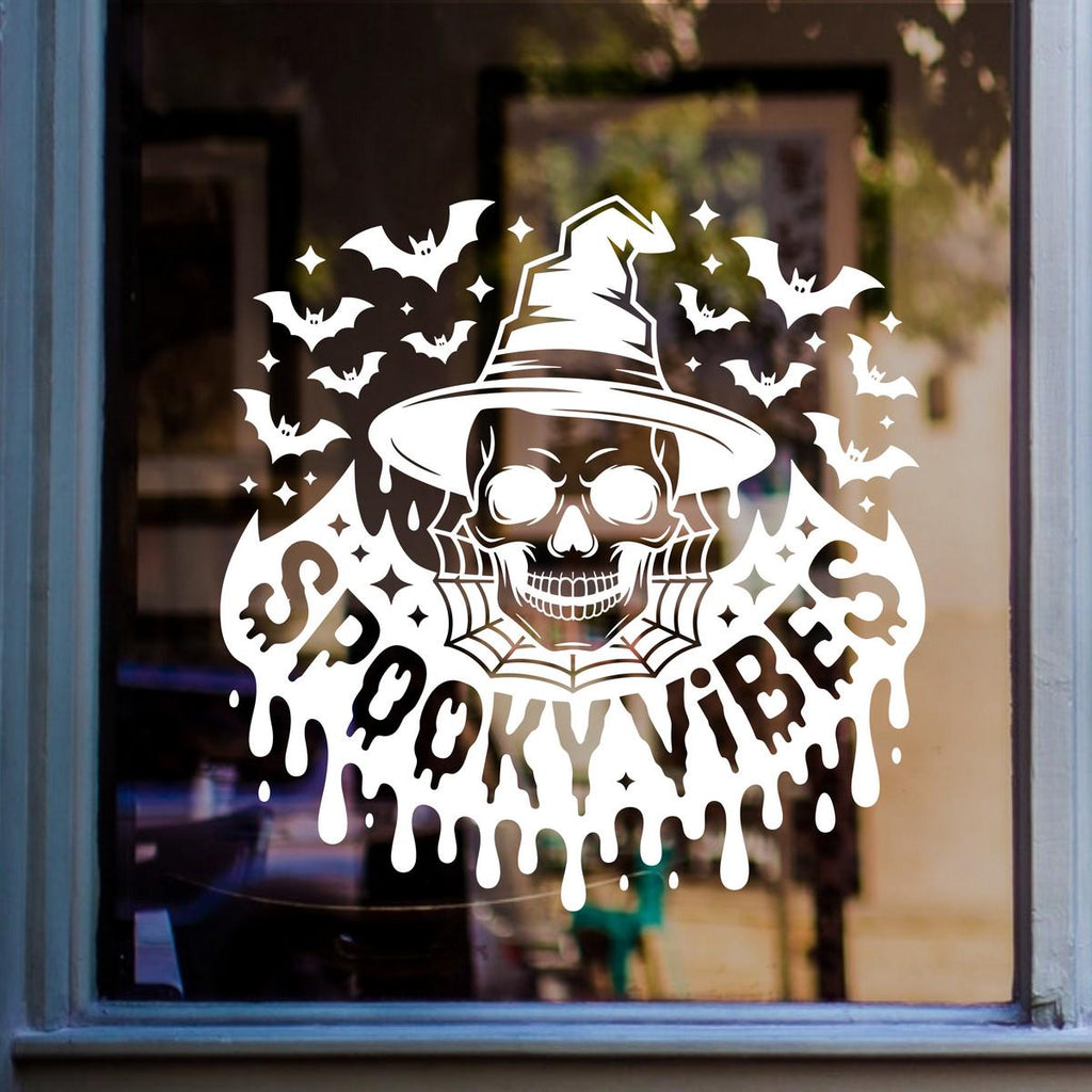 Spooky Vibes Witch Skull & Bat Swarm Window Sticker: white vinyl design on a blue-framed glass door
