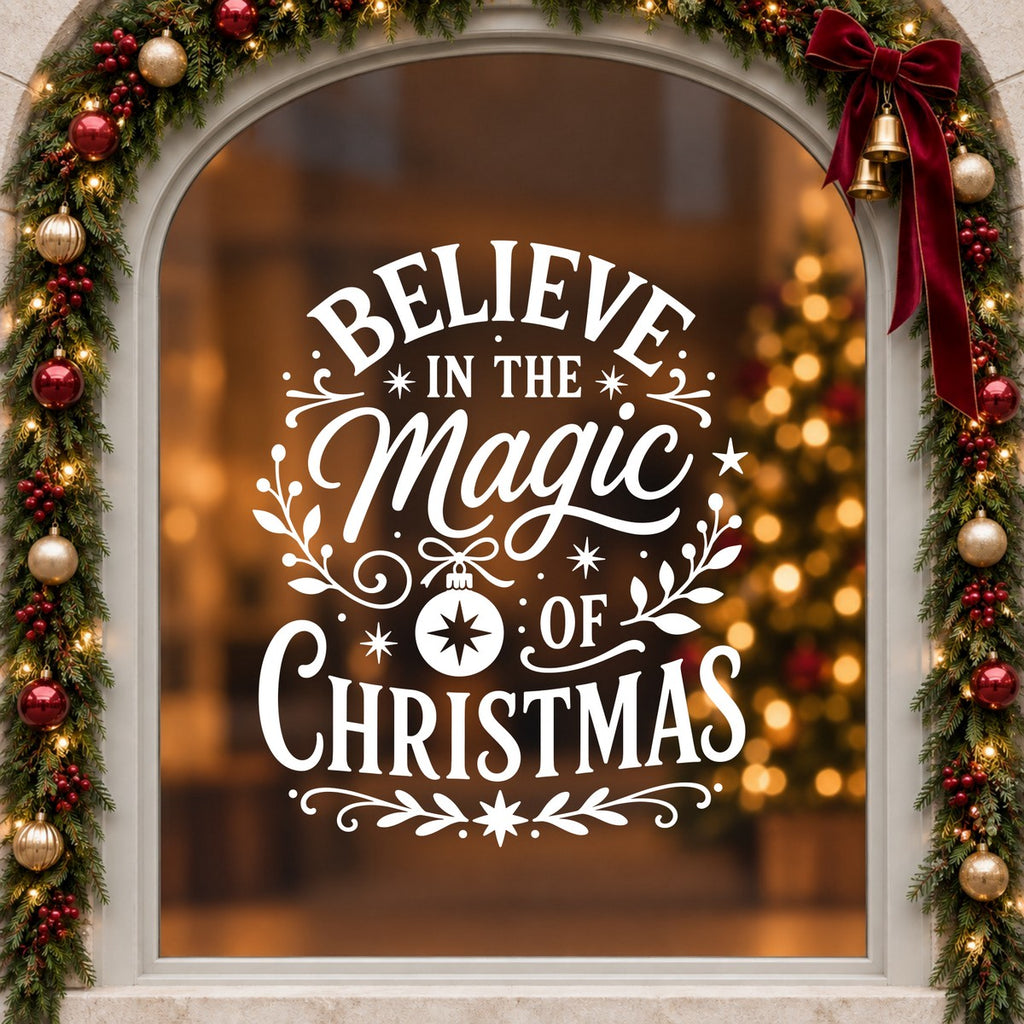 Believe in the Magic of Christmas Window Sticker in white on an arched cream window with a Christmas garland and red bow