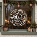 Round Most Wonderful Time of the Year Window Sticker in white on a sage green framed window decorated for Christmas