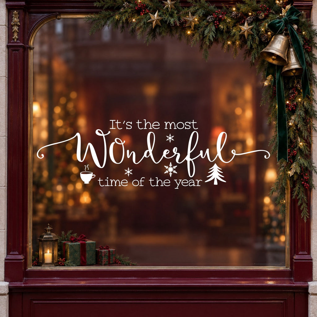 Wonderful Time of the Year Christmas Window Sticker in white on a burgundy shop window with festive greenery, bells and gifts