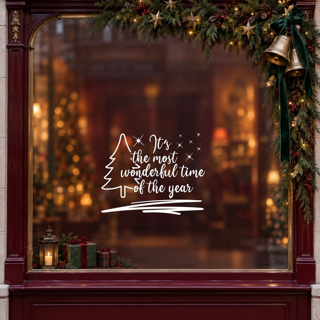 Wonderful Time of the Year Tree Window Sticker in white on a burgundy shop window with festive greenery, bells and gifts