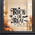Trick or Treat Cobweb window sticker showing ornate Trick or Treat lettering with a cobweb, bat and Halloween details, black vinyl on a light shop window with a dark charcoal frame