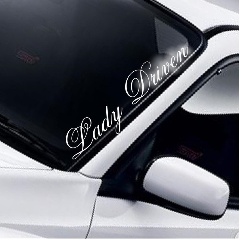 Lady Driven ornate script white vinyl windscreen sticker fitted to a car
