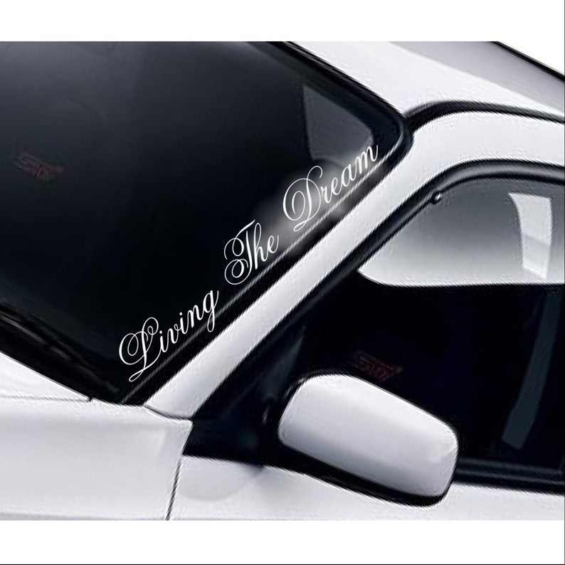 Living The Dream ornate script white vinyl windscreen sticker fitted to a car