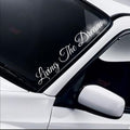 Living The Dream script white vinyl windscreen sticker fitted to a car