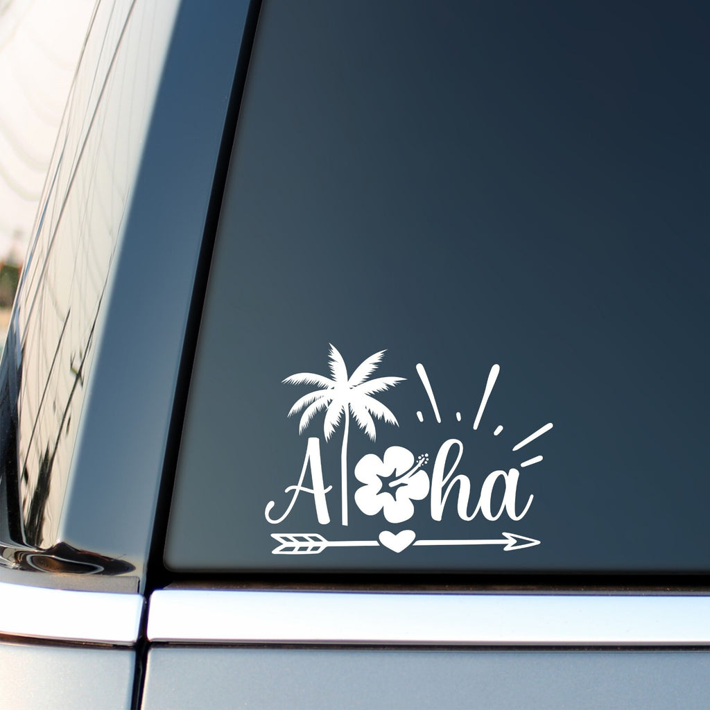 White Aloha tropical decal with a heart arrow on a vehicle side window.