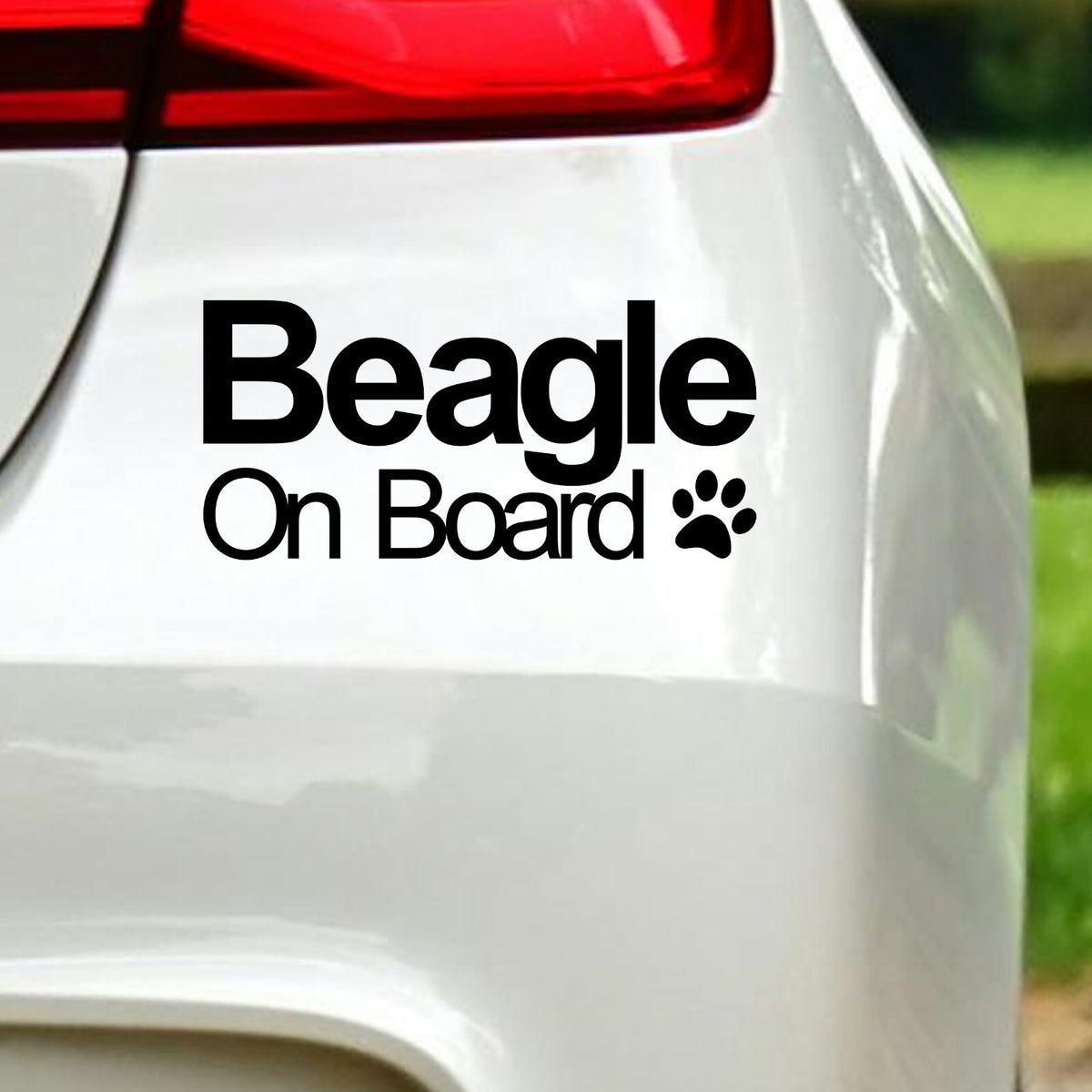 Black Beagle On Board decal below the rear light of a white car.