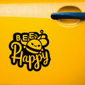 Black Bee Happy bold lettering sticker on a yellow car door.