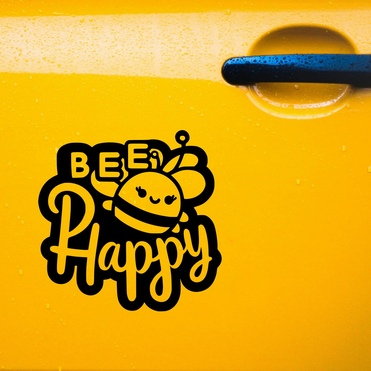 Black Bee Happy bold lettering sticker on a yellow car door.