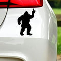 Black bigfoot middle finger sticker on white car bodywork beneath a rear light.