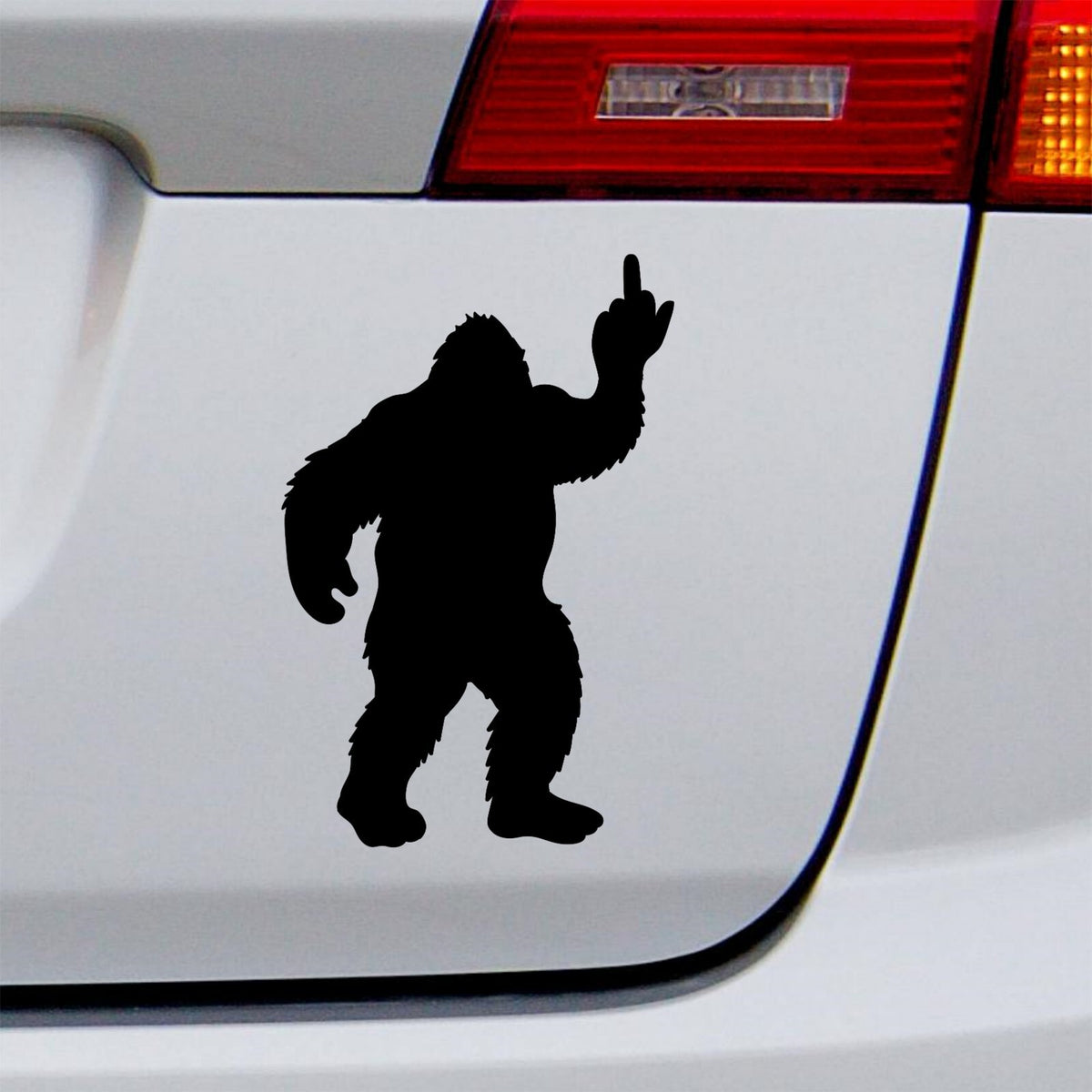 Black bigfoot middle finger decal on a white vehicle tailgate.