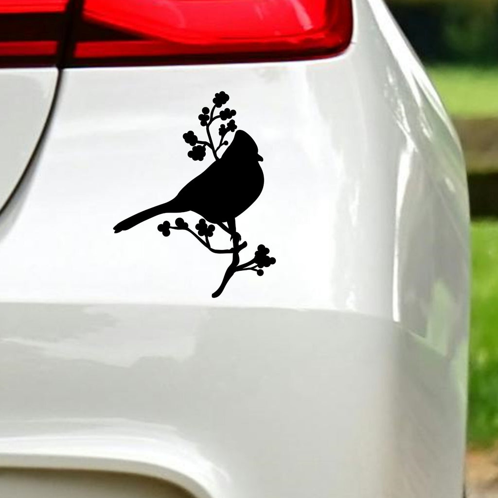 Black bird on a blossom branch sticker on white car bodywork beneath a rear light.
