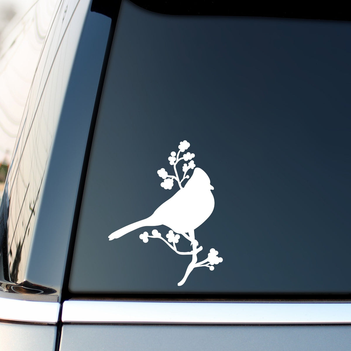 White bird on a blossom branch sticker on a vehicle side window.