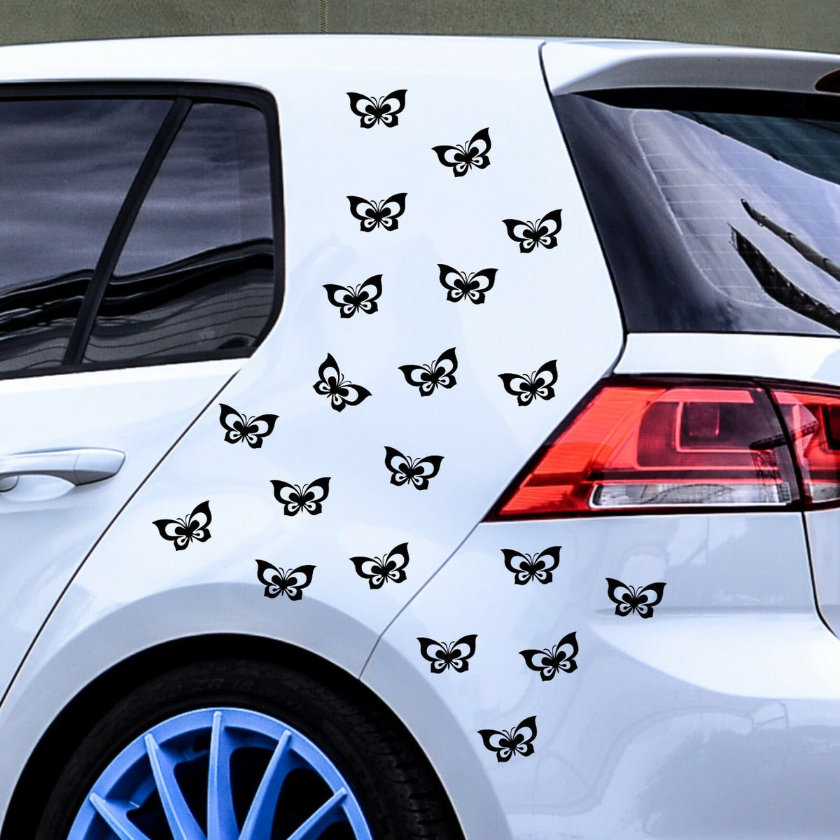 Black butterfly stickers arranged on a white car.