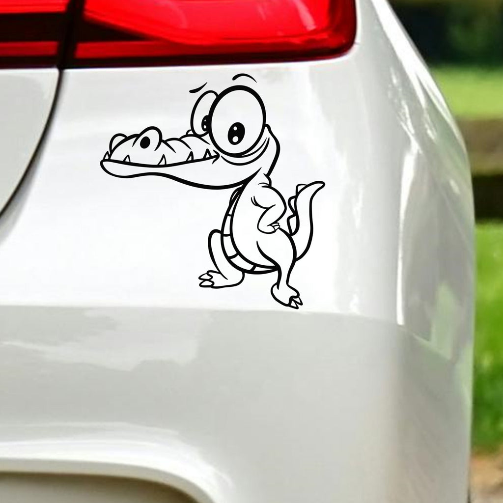Black cartoon crocodile sticker on white car bodywork beneath a rear light.