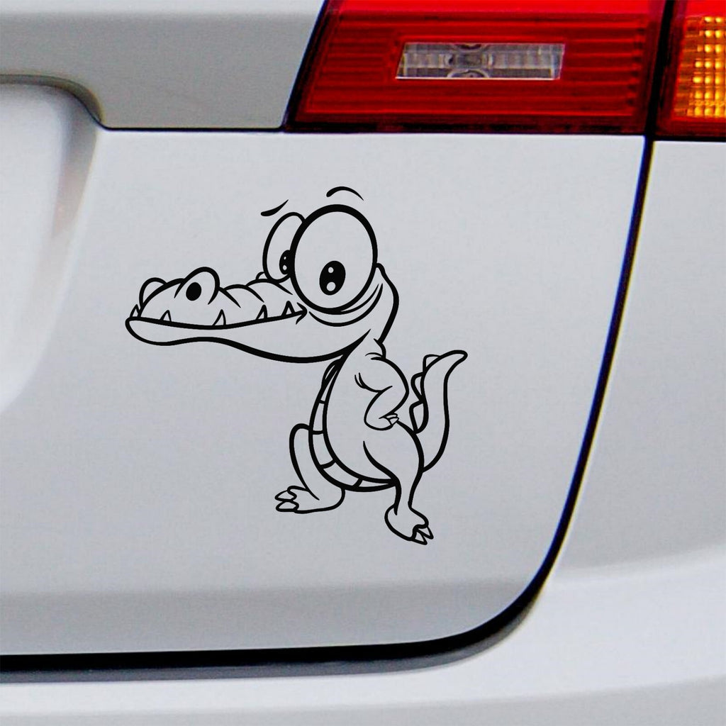 Black cartoon crocodile decal on a white vehicle tailgate.