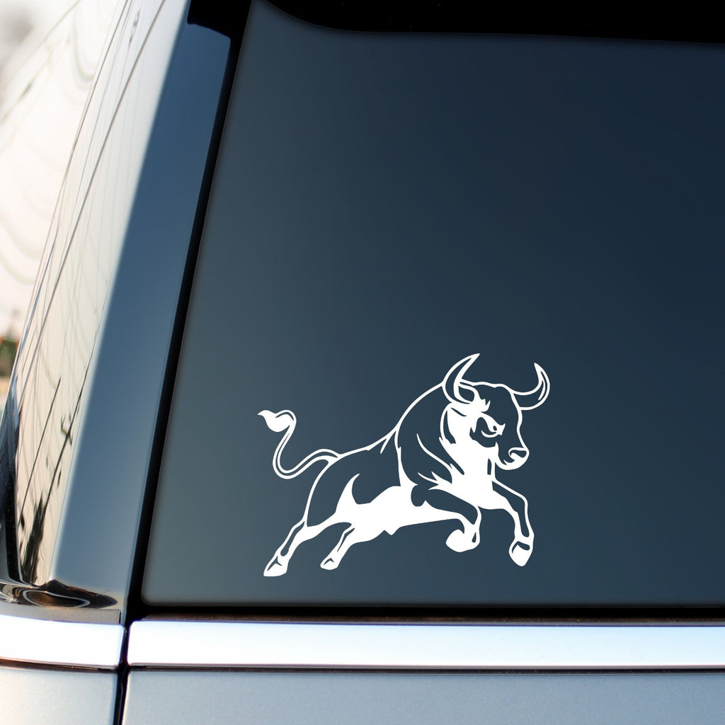 White charging bull sticker on a vehicle side window.