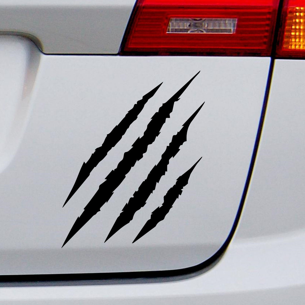 Black claw scratch marks decal on a white vehicle tailgate.