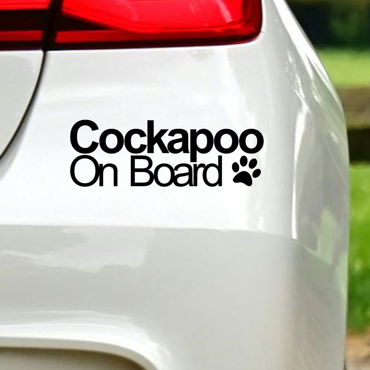 Black Cockapoo On Board decal below the rear light of a white car.