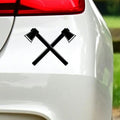 Black crossed axes sticker on white car bodywork beneath a rear light.