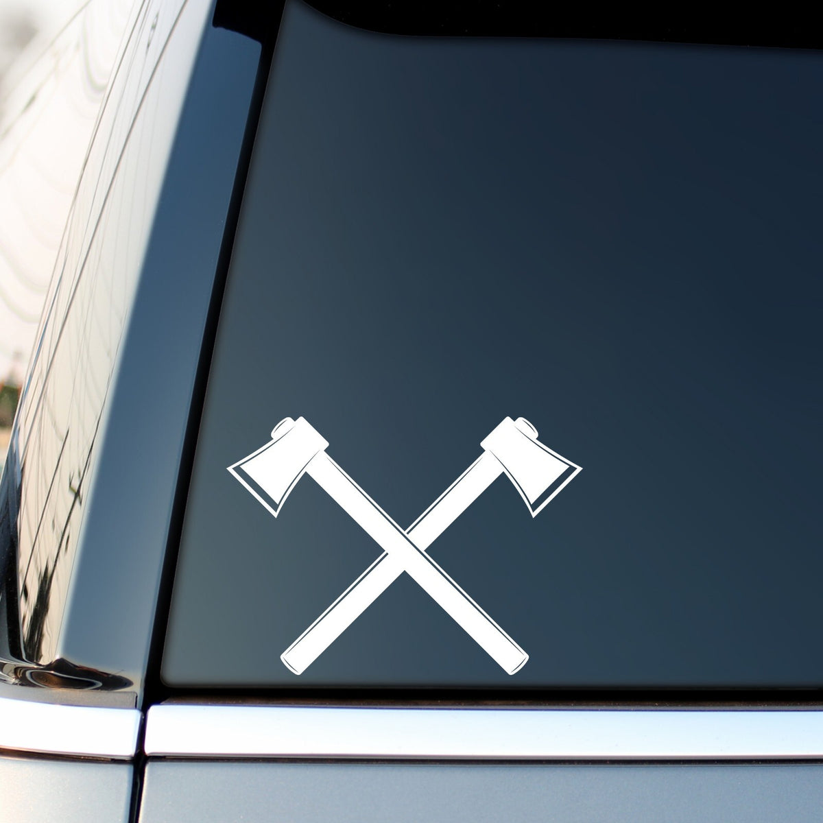 White crossed axes sticker on a vehicle side window.