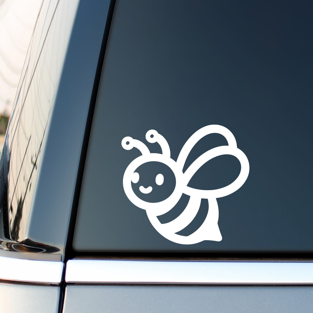 White cute smiling bee decal on a vehicle side window.