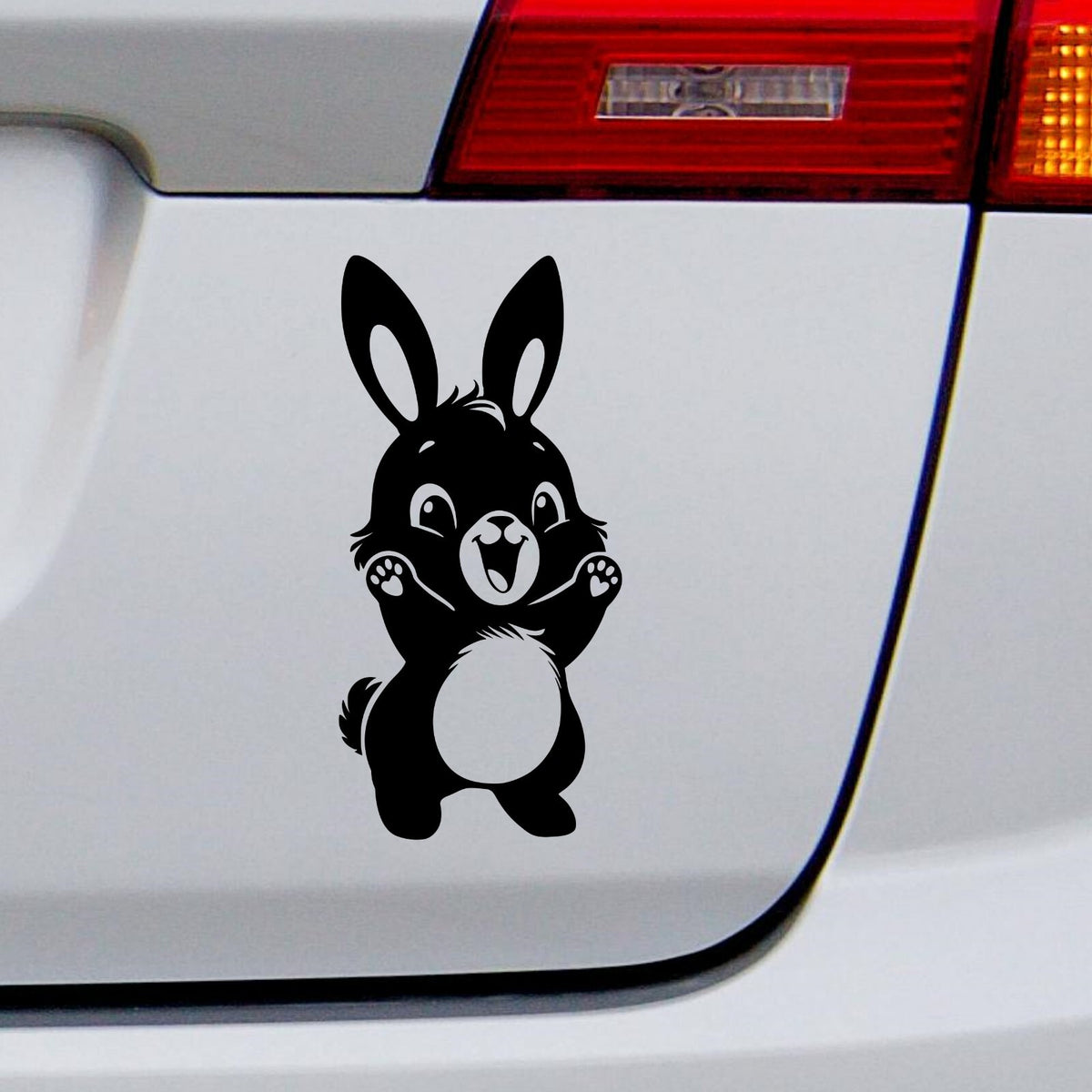 Black cute bunny rabbit decal on a white vehicle tailgate.