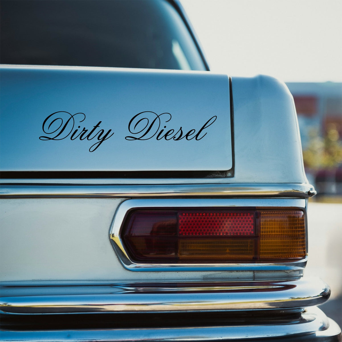 Black Dirty Diesel elegant script sticker on the rear panel of a pale blue classic car.