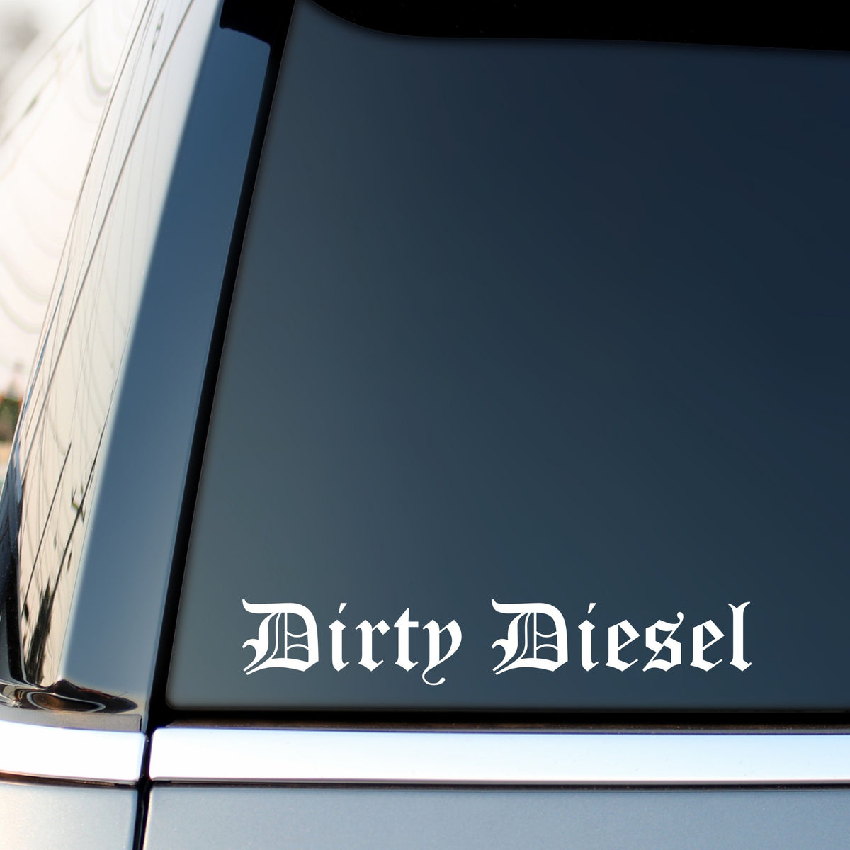White Dirty Diesel gothic lettering decal on a dark vehicle side window.