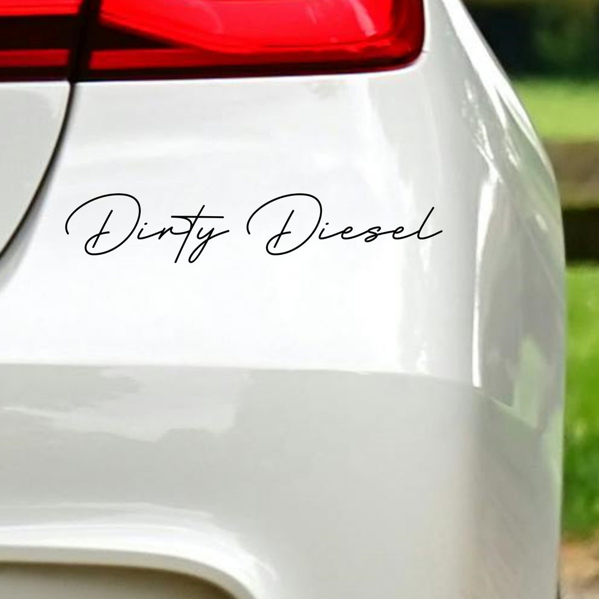 Black Dirty Diesel decal in fine flowing script on white vehicle bodywork beneath a rear light.