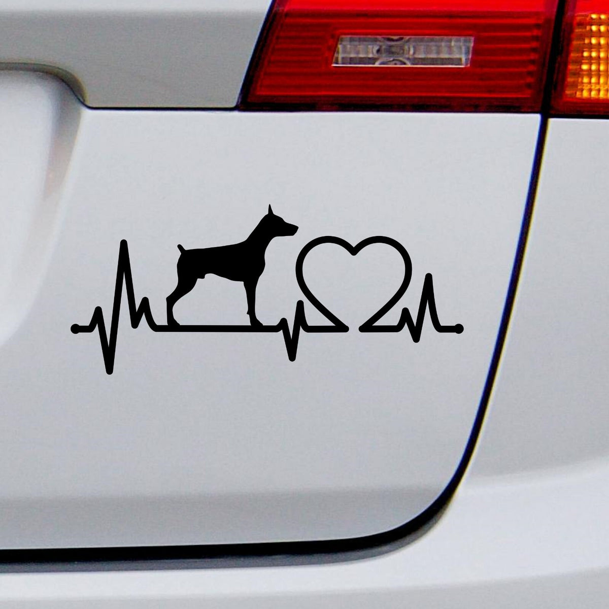Black Doberman Heartbeat decal on a white car rear panel.