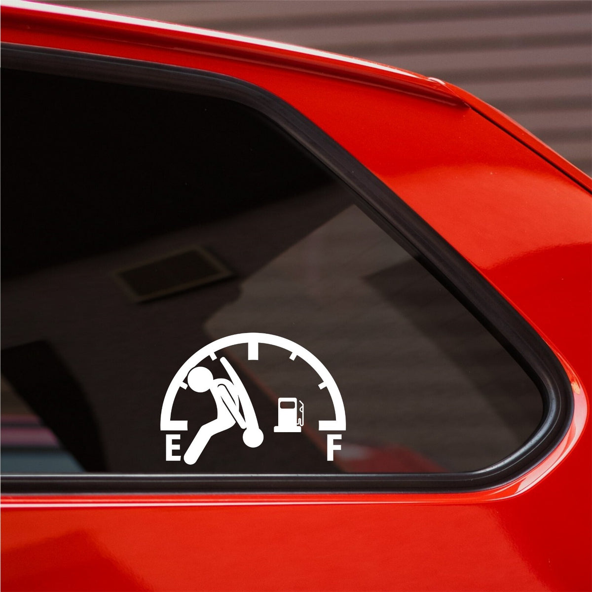 White empty fuel gauge decal on the rear side window of a red car.