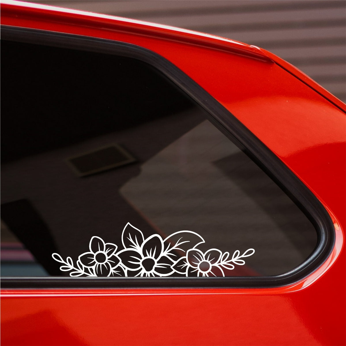 White floral flower border decal on a red car's side window.