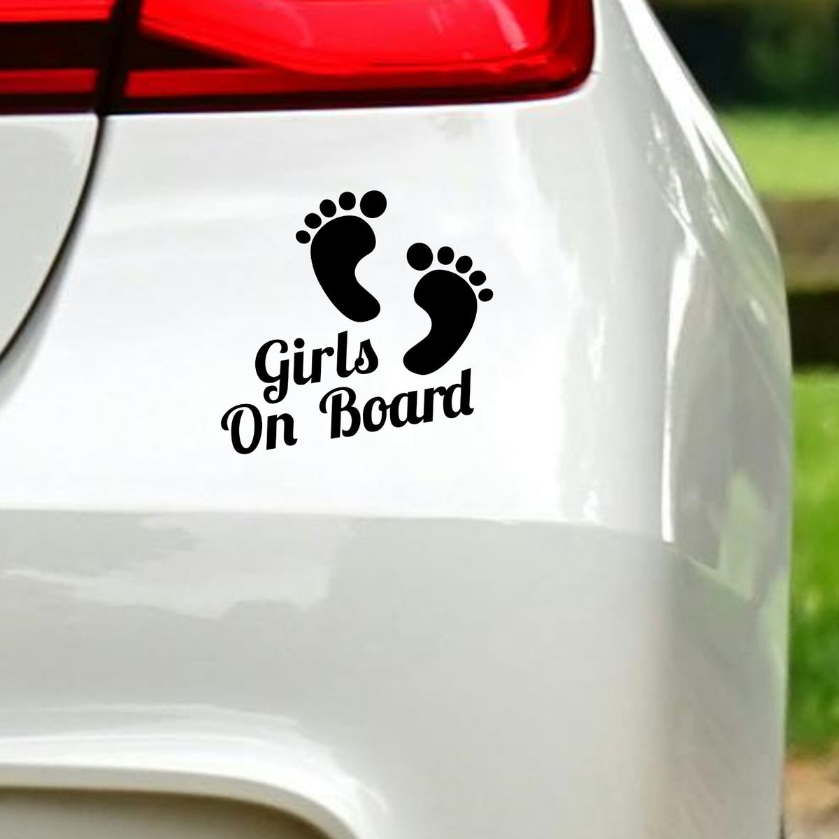 Black Girls On Board Footprints decal below the rear light of a white car.