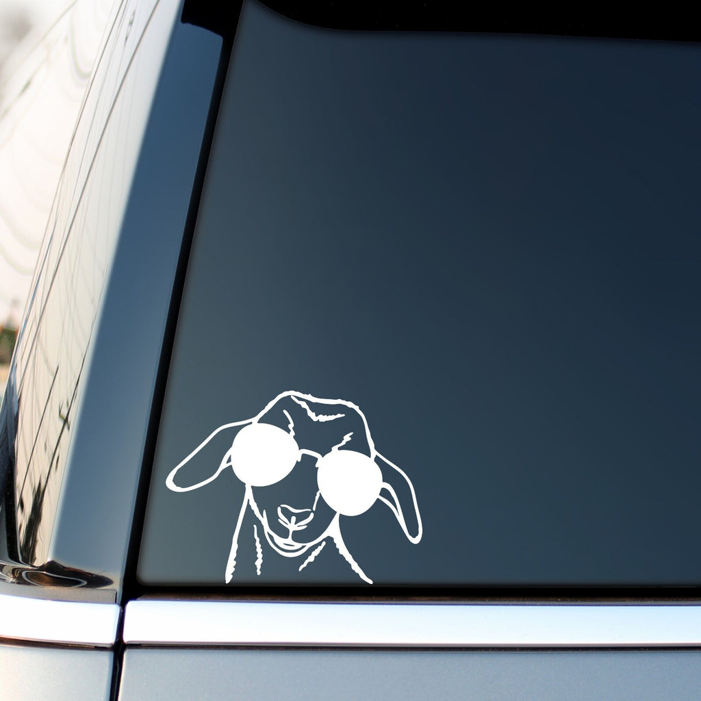 White goat with sunglasses sticker on a vehicle side window.