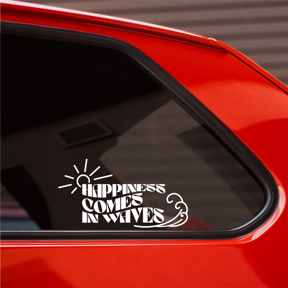 White Happiness Comes In Waves sun and wave decal on the rear side window of a red car.