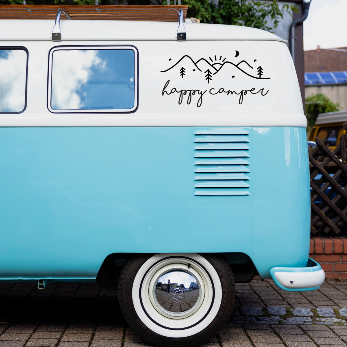 Happy Camper mountain and pine tree decal on a turquoise and white campervan.