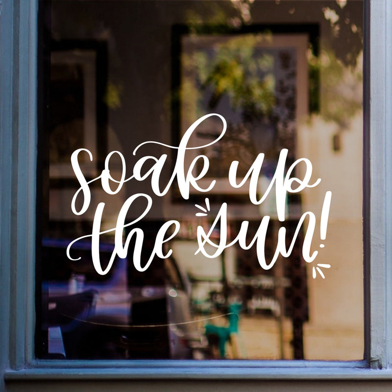 Soak Up The Sun summer window sticker displayed on glass