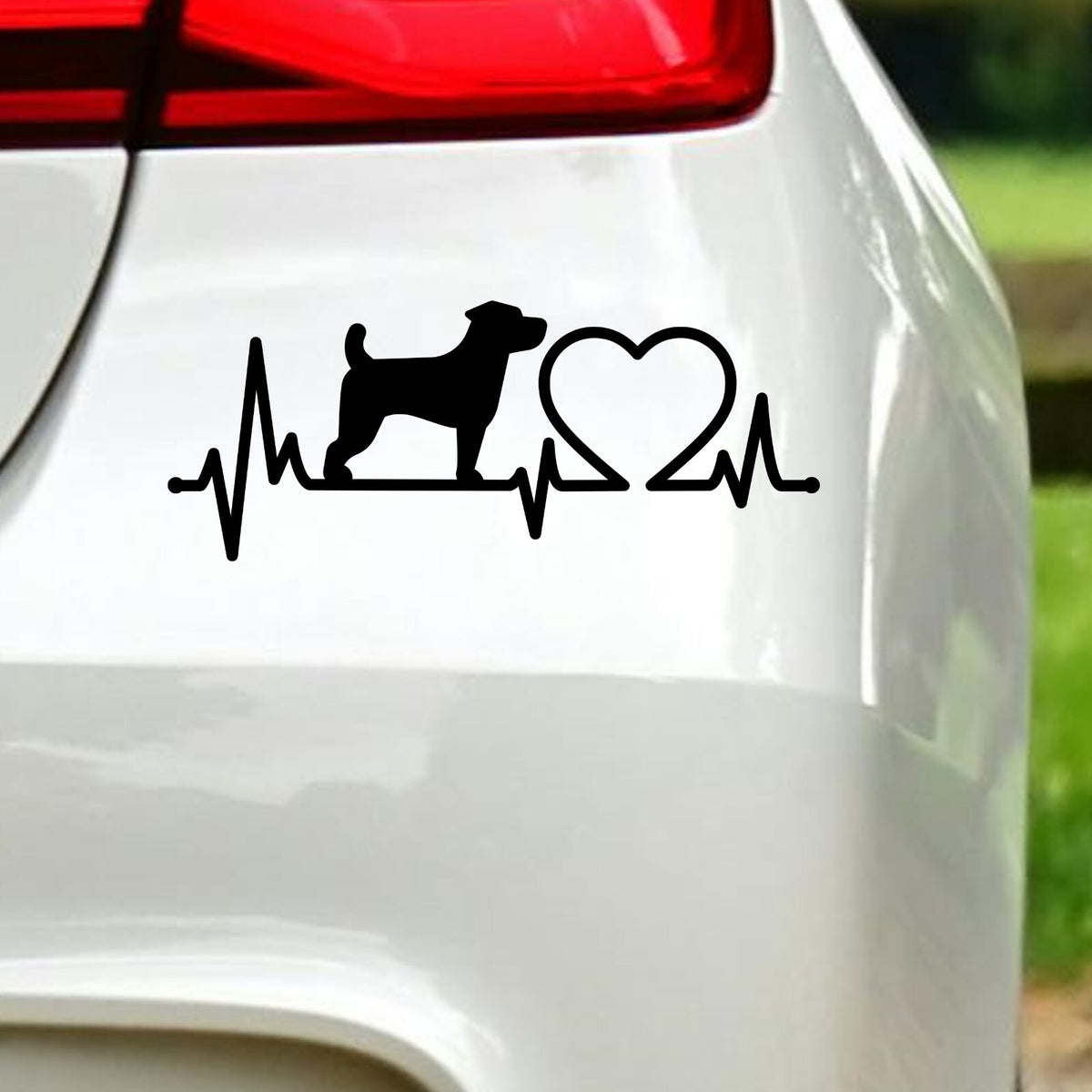Black jack russell heartbeat sticker on white car bodywork beneath a rear light.