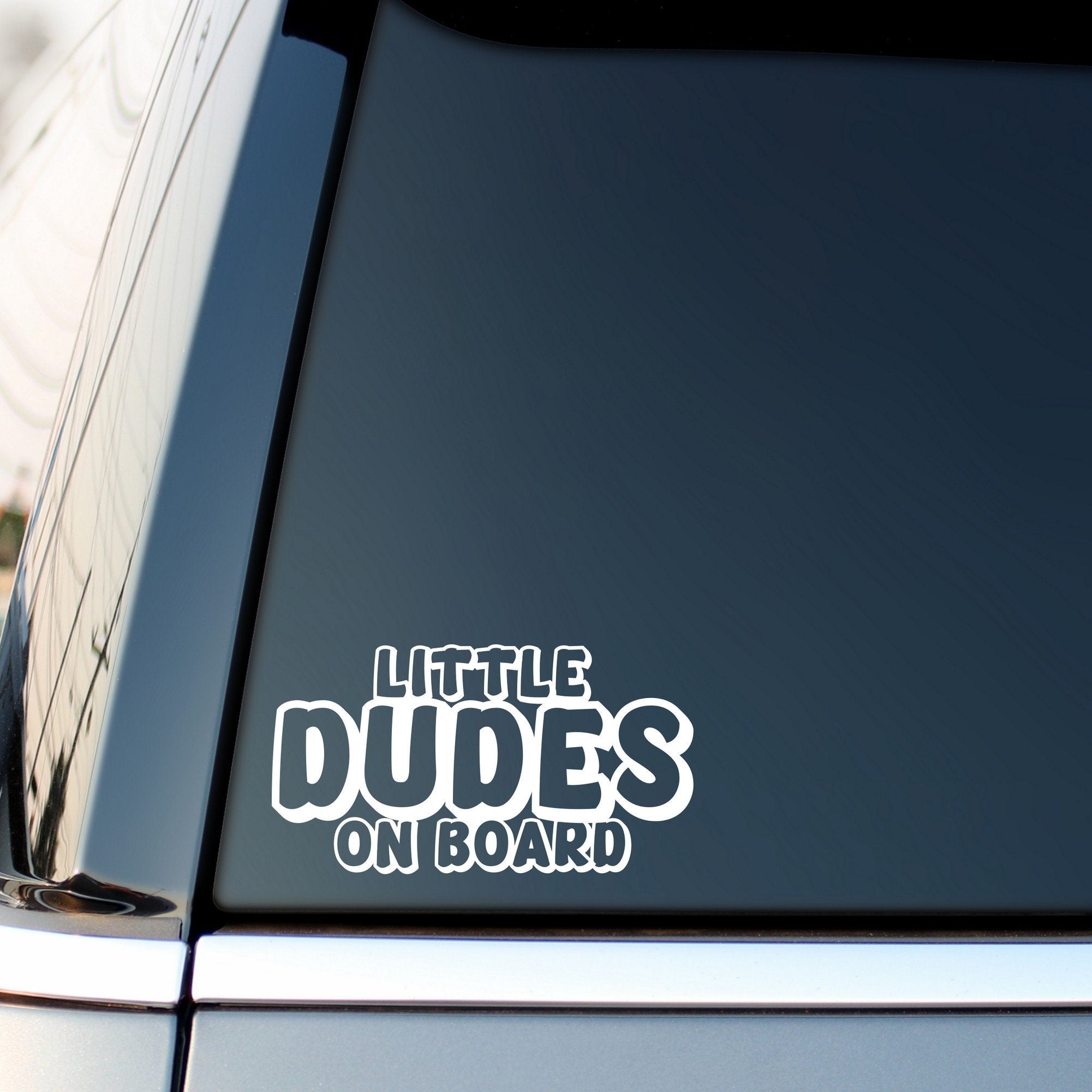 Little Dudes On Board outline car sticker shown on a vehicle rear window