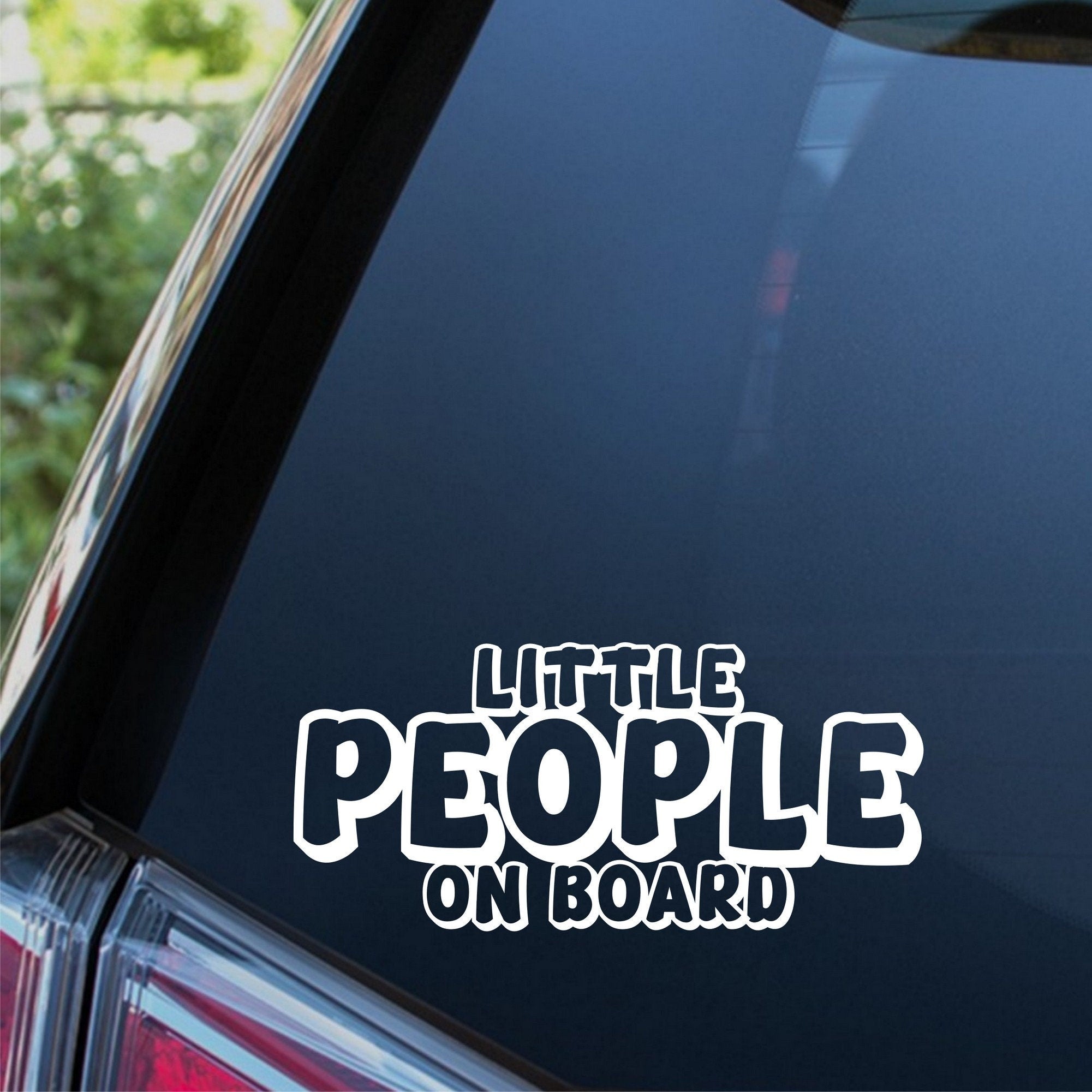 Little People On Board outline car sticker shown on a dark vehicle window