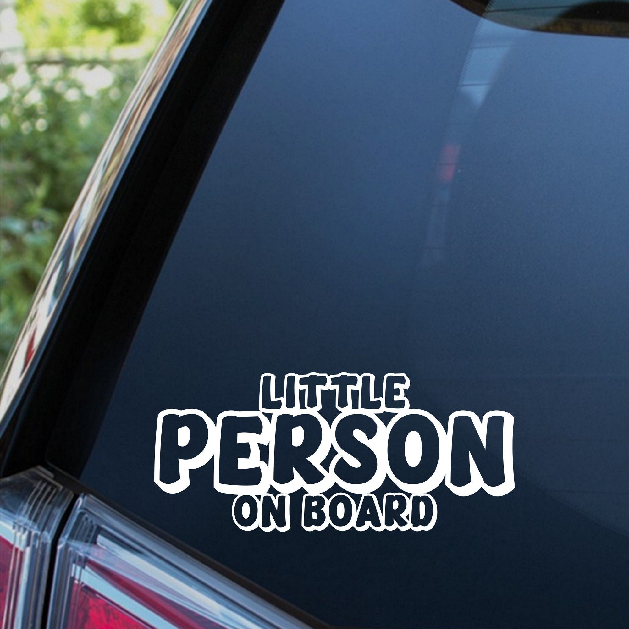 Little Person On Board outline car sticker shown on a dark vehicle window