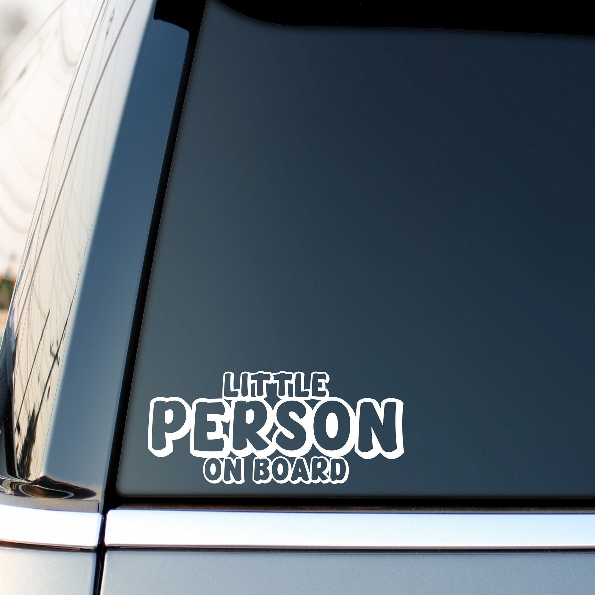 Little Person On Board outline car sticker shown on a vehicle rear window