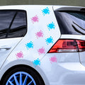 Light pink and light blue paint splat stickers arranged on a white car.