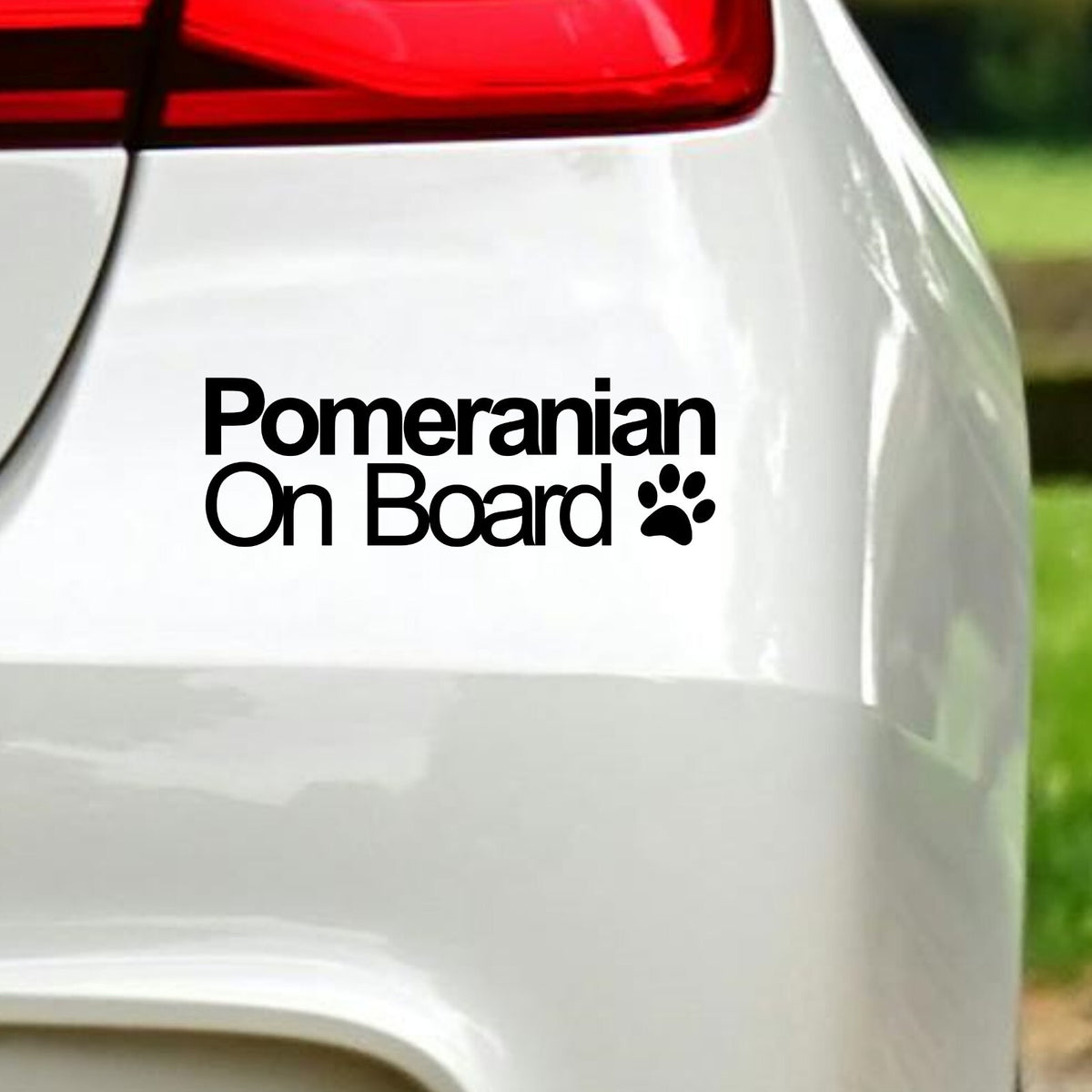 Black Pomeranian On Board decal below the rear light of a white car.
