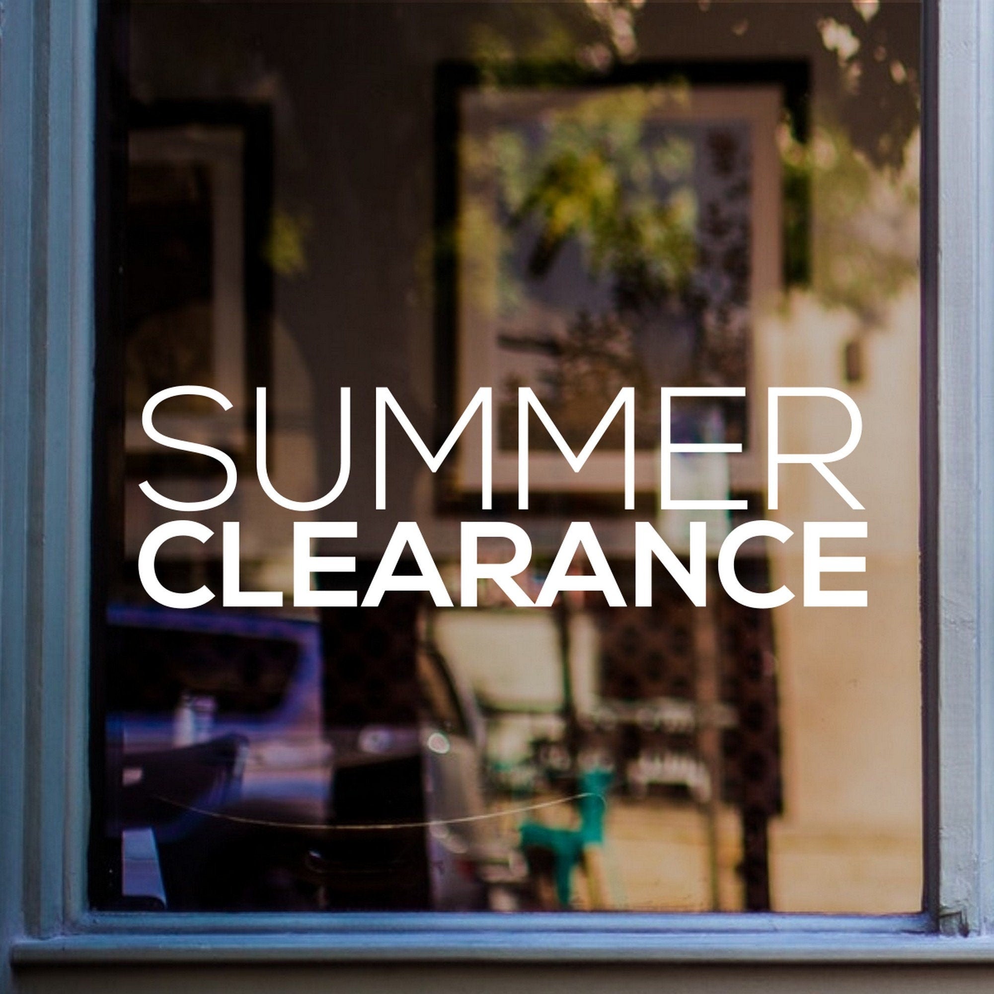 Summer Clearance Shop Window Sticker shown on a shop window